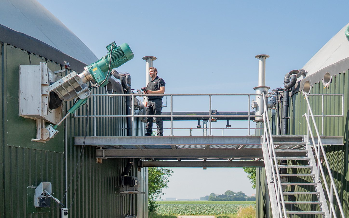 Plant manager staat op loopbrug tussen vergisters Luttelgeest (Peters Biogas)