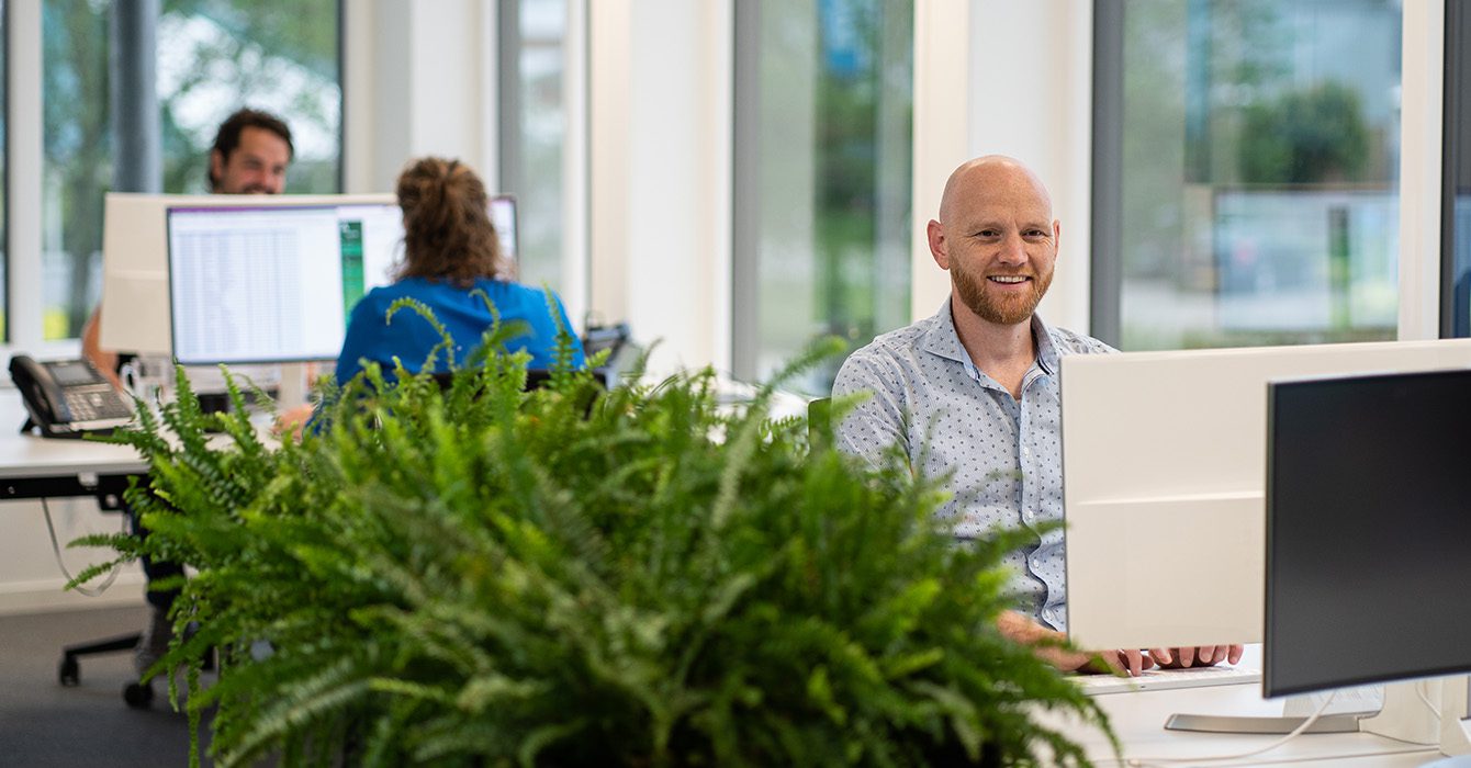 Marketing En IT Specialist Leon Vrolijk Voor Computer, Medewerkers Aan Het Werk Bij Bureau Op De Achtergrond